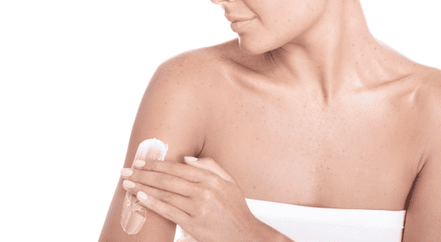 Frau cremt sich die Haut ein, um Mikrobiom zu schützen